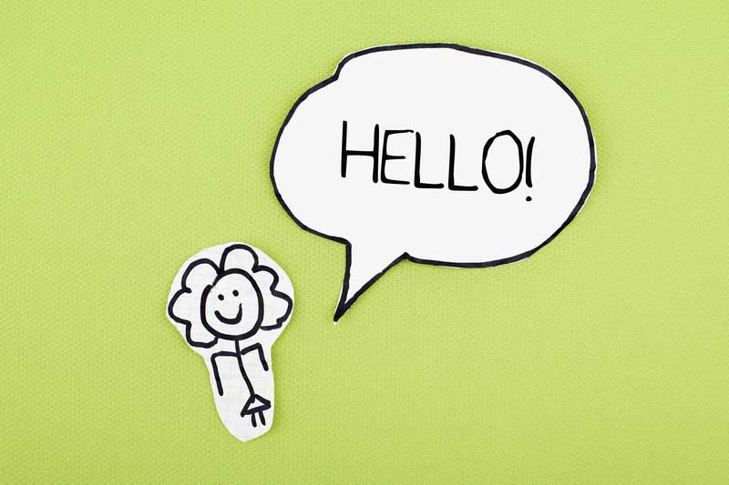 paper cut out girl with word bubble that says hello